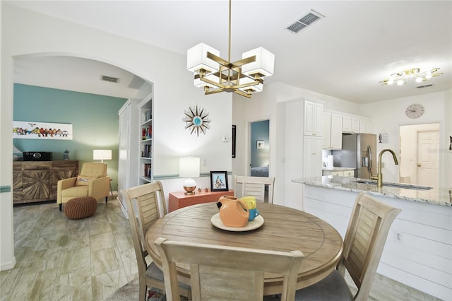 dining space with sink and an inviting chandelier