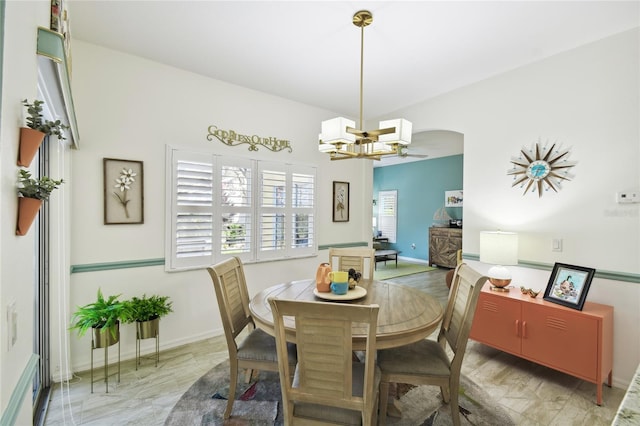 dining area with ceiling fan with notable chandelier