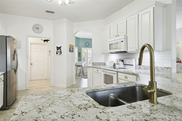 kitchen featuring white appliances, light hardwood / wood-style floors, white cabinetry, and sink