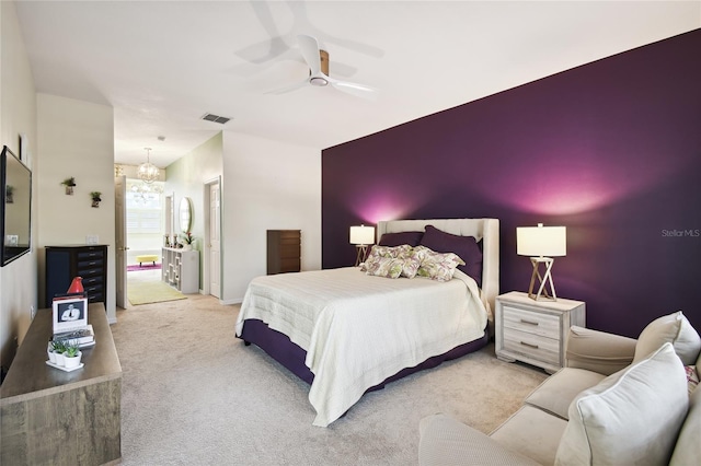 carpeted bedroom featuring ceiling fan with notable chandelier