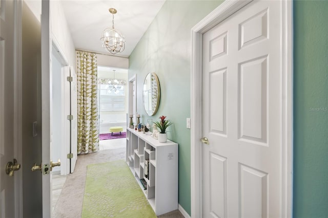 hall featuring a chandelier and light carpet