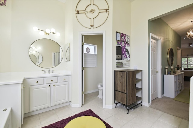 bathroom featuring tile patterned floors, vanity, toilet, and a notable chandelier