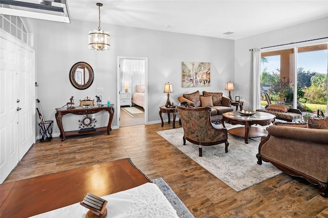 living room featuring hardwood / wood-style flooring and an inviting chandelier