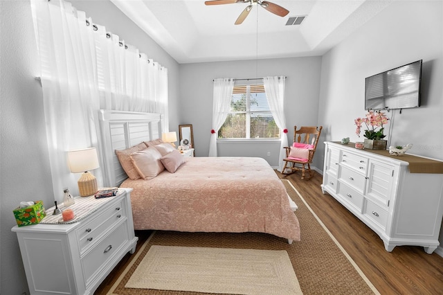 12213 Still Meadow Dr, Clermont, FL 34711 - bedroom with dark wood-style floors, a raised ceiling, and a ceiling fan