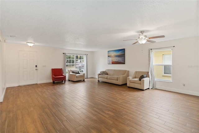 unfurnished living room with ceiling fan, wood-type flooring, and a textured ceiling