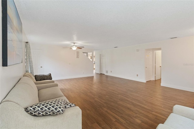 living room with ceiling fan, a textured ceiling, and hardwood / wood-style flooring