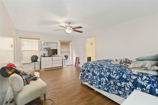 bedroom with ceiling fan, wood-type flooring, and a textured ceiling