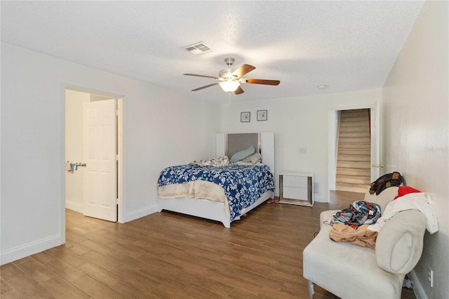 bedroom featuring hardwood / wood-style floors, ceiling fan, and a textured ceiling