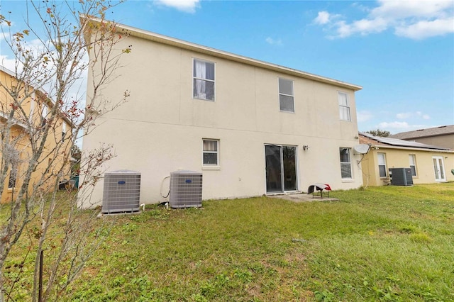 back of property with a yard and central air condition unit