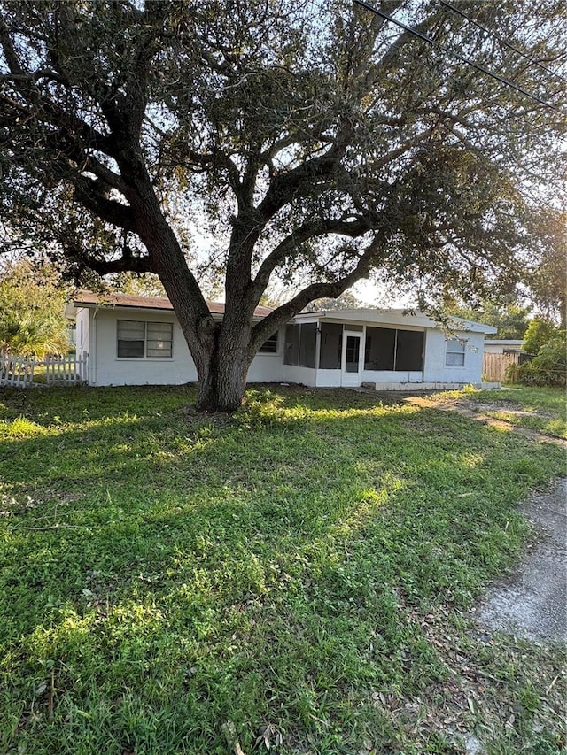 view of front facade with a front lawn and a sunroom