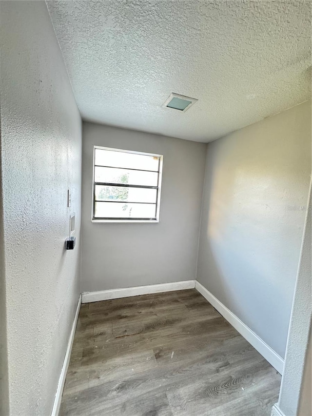 empty room featuring hardwood / wood-style flooring and a textured ceiling