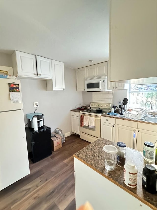 kitchen featuring decorative backsplash, dark stone countertops, white cabinets, white appliances, and dark hardwood / wood-style flooring