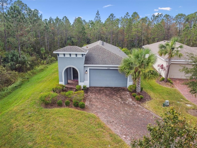 mediterranean / spanish-style home with a garage and a front lawn