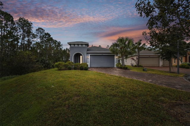 view of front of property featuring a garage and a yard