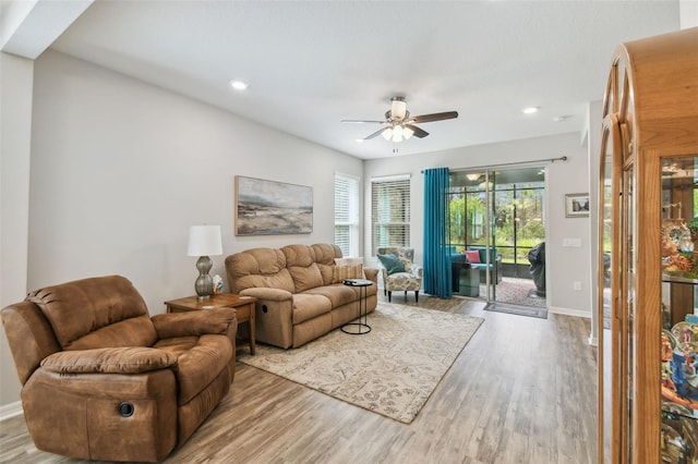 living room with light wood-type flooring and ceiling fan