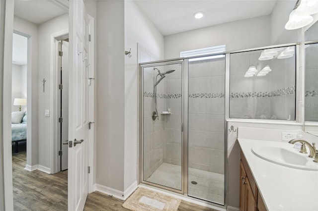 bathroom featuring walk in shower, vanity, and hardwood / wood-style floors