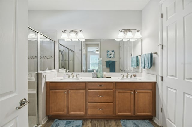 bathroom featuring an enclosed shower, vanity, ceiling fan, and wood-type flooring