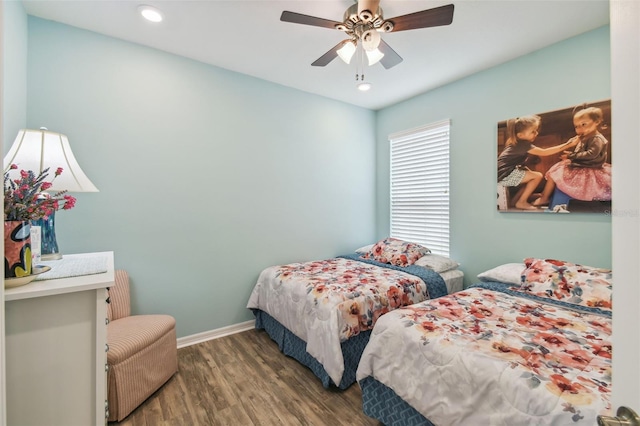 bedroom with dark hardwood / wood-style flooring and ceiling fan