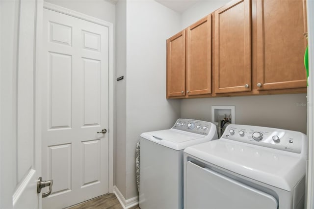 laundry area with hardwood / wood-style floors, washer and clothes dryer, and cabinets