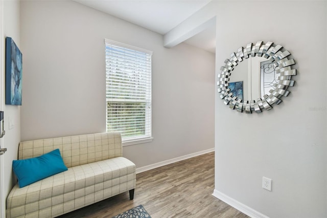 living area with hardwood / wood-style floors and beam ceiling