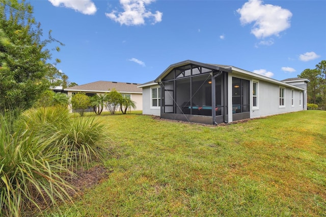 rear view of property with a sunroom and a yard