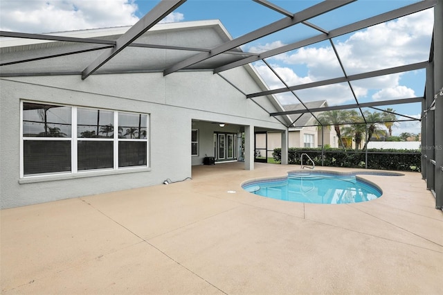 view of pool featuring glass enclosure and a patio