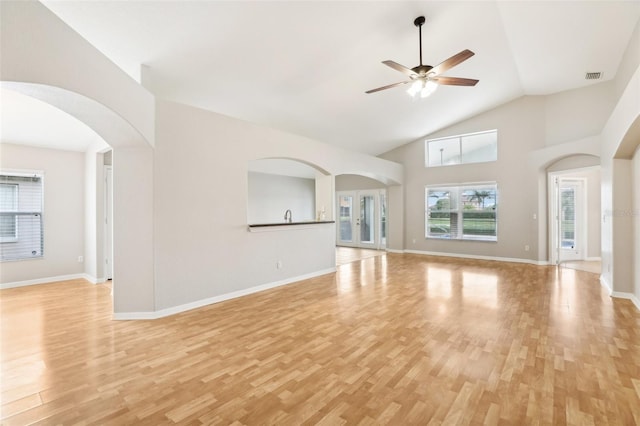 unfurnished living room featuring ceiling fan, light wood-type flooring, and high vaulted ceiling