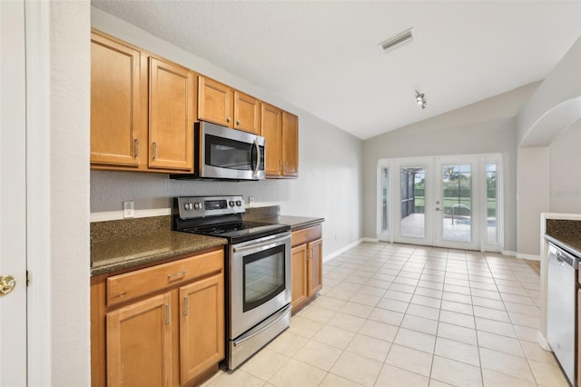 kitchen featuring lofted ceiling, stainless steel appliances, light tile patterned floors, and french doors