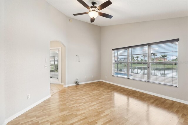 unfurnished room with ceiling fan, light hardwood / wood-style flooring, and vaulted ceiling