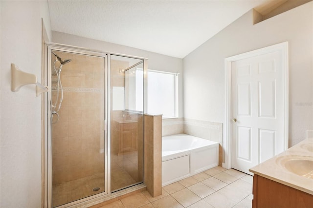 bathroom with tile patterned flooring, vanity, plus walk in shower, and vaulted ceiling