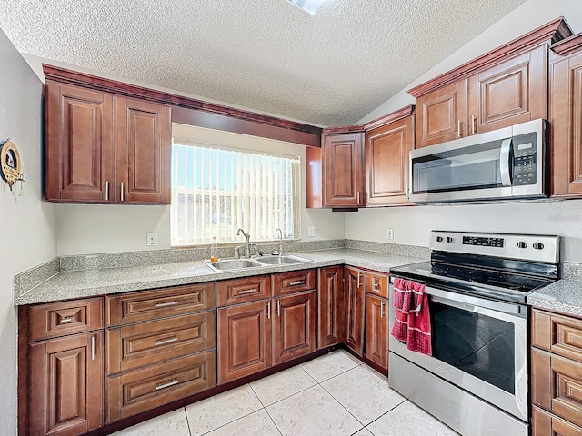 kitchen with sink, appliances with stainless steel finishes, a textured ceiling, and light tile patterned floors