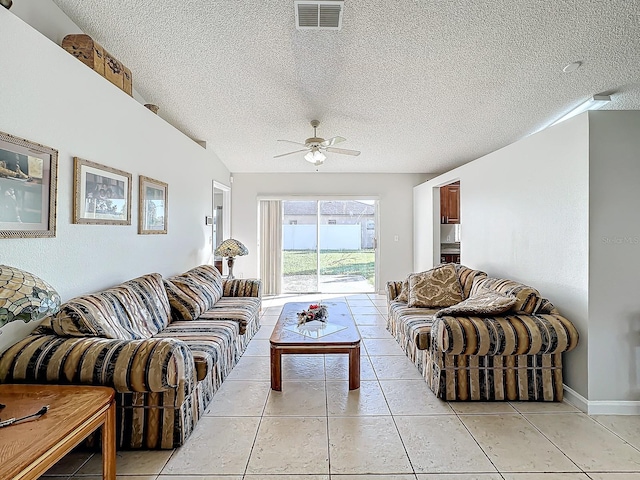 tiled living room with a textured ceiling and ceiling fan