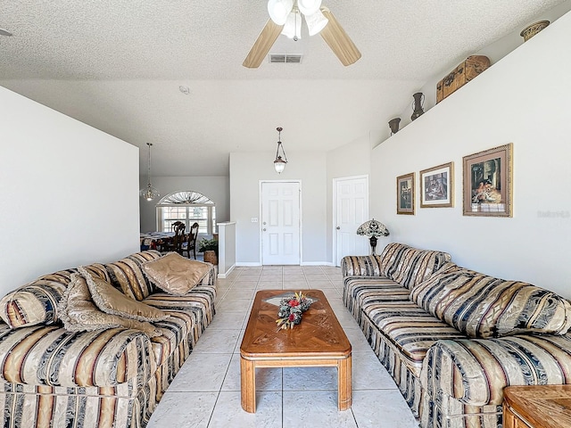 living room with a textured ceiling, ceiling fan, and light tile patterned floors