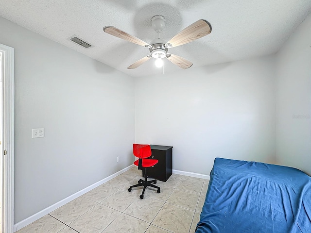 tiled bedroom with a textured ceiling and ceiling fan