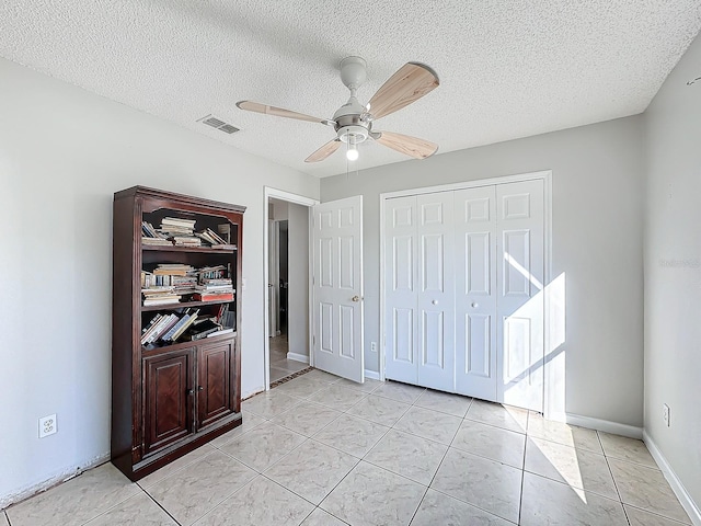 tiled bedroom featuring a textured ceiling and ceiling fan