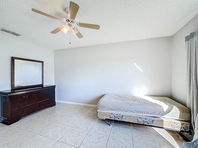 tiled bedroom with a textured ceiling and ceiling fan