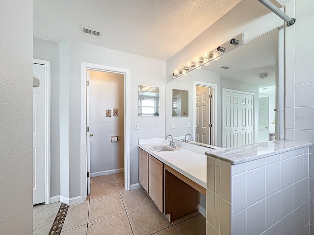 bathroom featuring vanity, a textured ceiling, and tile patterned floors