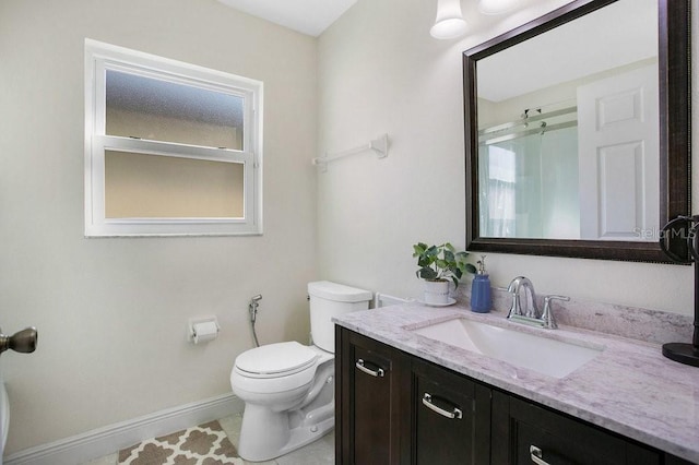 bathroom with toilet, vanity, and tile patterned flooring