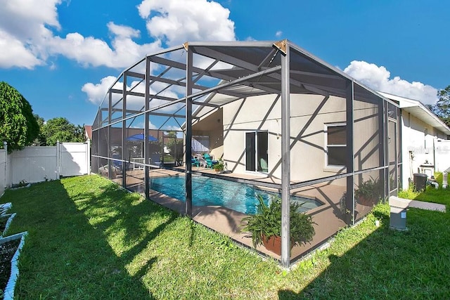 view of swimming pool with a patio area, a lawn, and glass enclosure