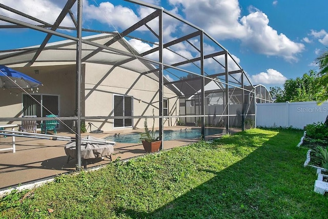 view of swimming pool featuring a patio, a yard, and glass enclosure