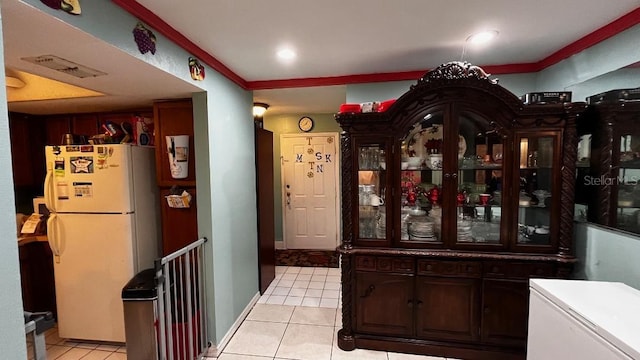 kitchen featuring light tile patterned flooring, dark brown cabinetry, and white refrigerator