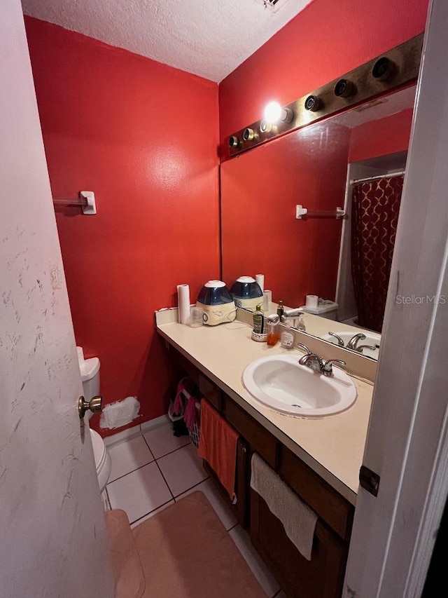 bathroom with tile patterned floors, toilet, a shower with shower curtain, vanity, and a textured ceiling