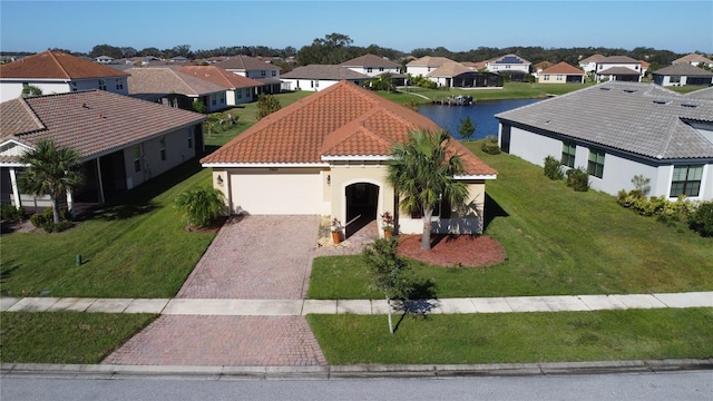 view of front of home with a water view, a front yard, and a garage