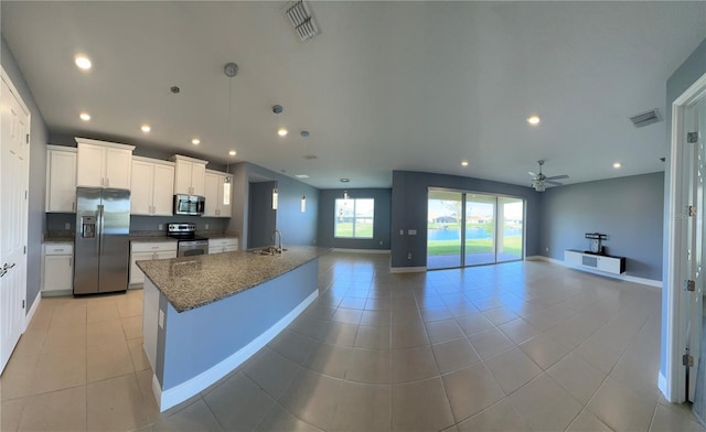 kitchen featuring appliances with stainless steel finishes, white cabinets, sink, and light tile patterned floors