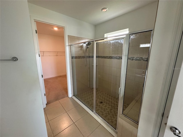 bathroom featuring a shower with shower door and tile patterned flooring