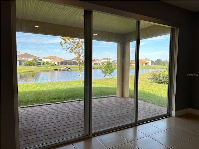 doorway to outside featuring a water view and tile patterned floors