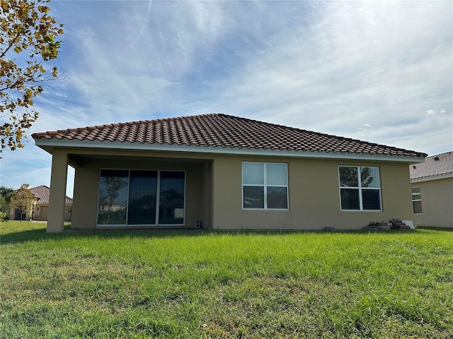 rear view of house featuring a yard