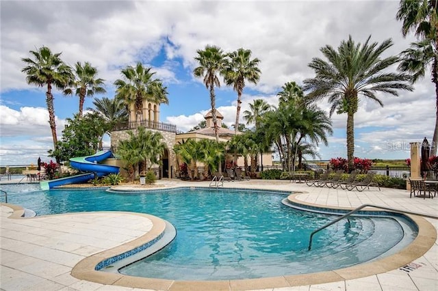 view of swimming pool with a patio area and a water slide