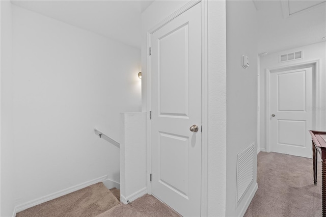 hallway featuring light colored carpet