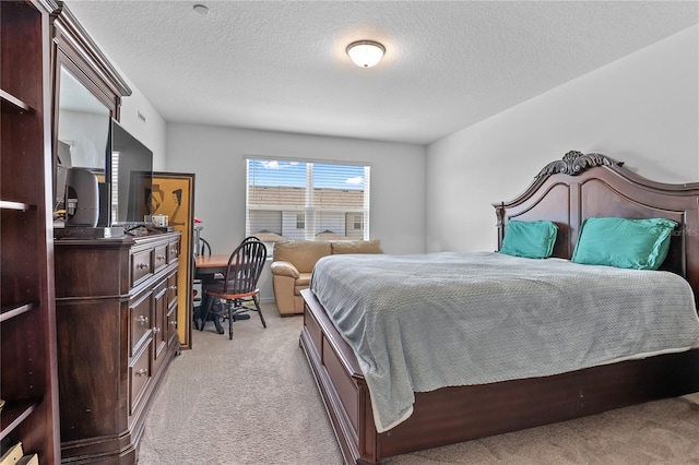 bedroom featuring a textured ceiling and light colored carpet